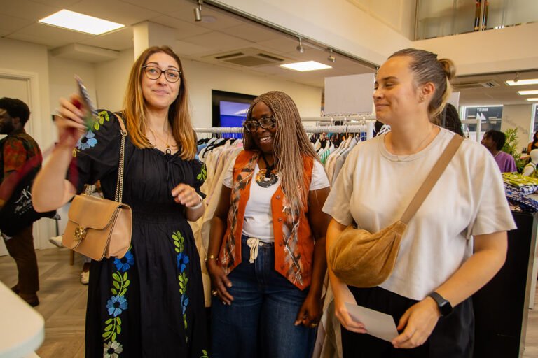 Three guests laughing together on the shop floor